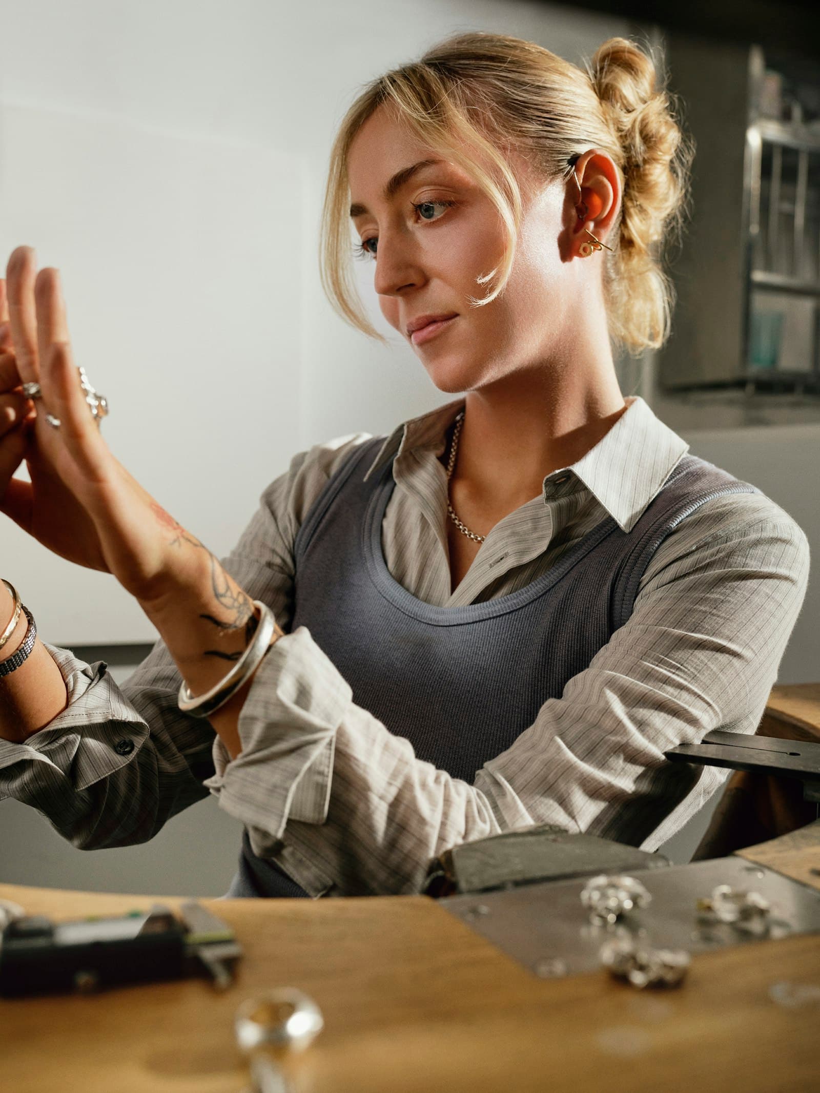 Jeweller examining a piece of jewellery at a workbench in a bright studio