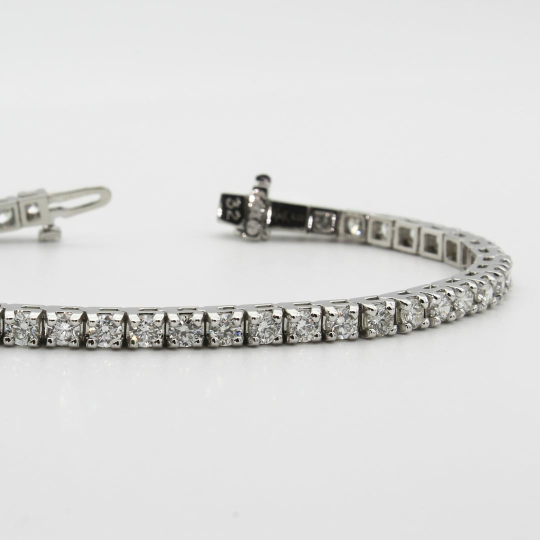 Diamond tennis bracelet laid flat on a pale background
