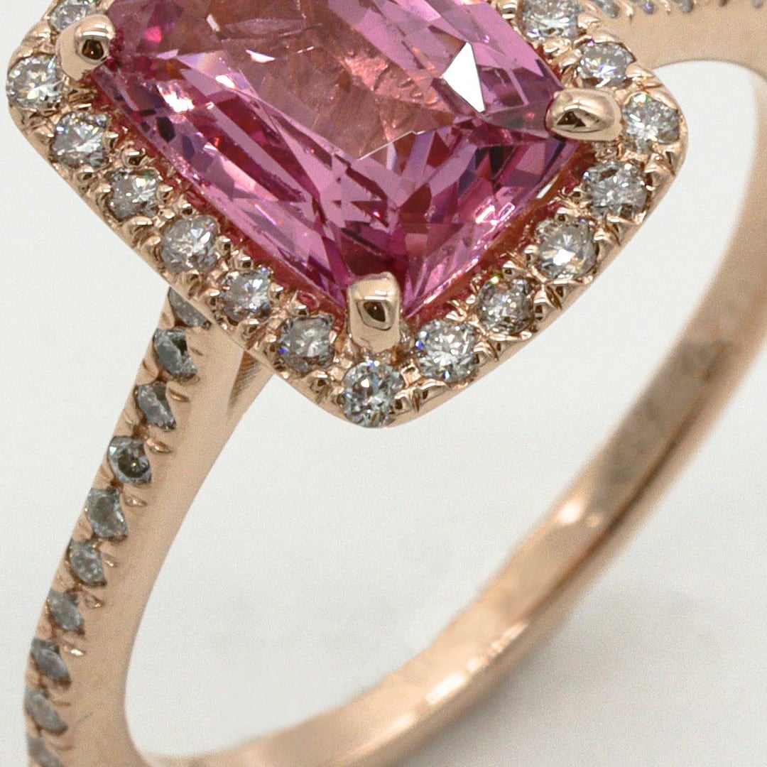 Close-up detail — rose gold ring with an emerald-cut pink gemstone surrounded by small diamonds